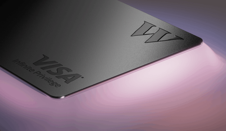 Close-up of the black metal Wealthsimple Visa Infinite Privilege credit card on a pink and lilac background, showing the embossed W logo and the Visa Infinite Privilege wordmark